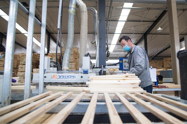 4月20日,在绥芬河一家木材加工企业生产车间,工人操作机器加工木材